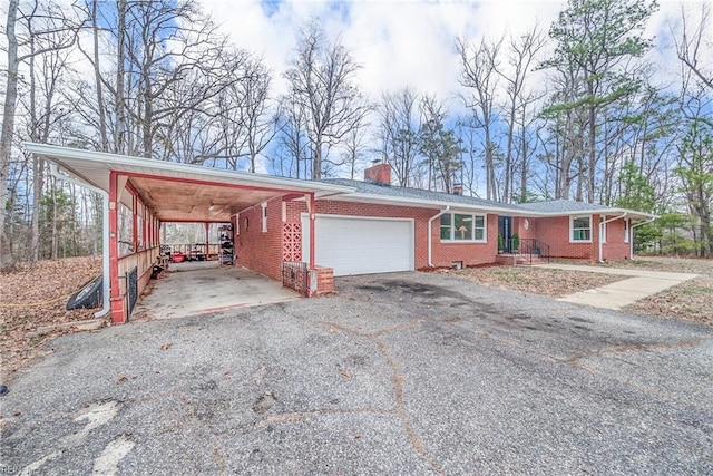 view of front of property with a garage, a chimney, aphalt driveway, a carport, and brick siding