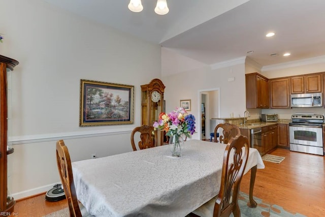 dining area with light wood-style floors, baseboards, crown molding, and recessed lighting