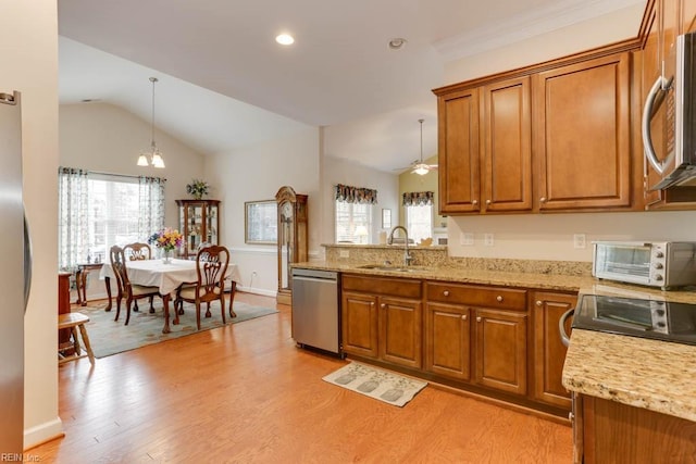 kitchen with stainless steel appliances, a toaster, brown cabinetry, and a sink