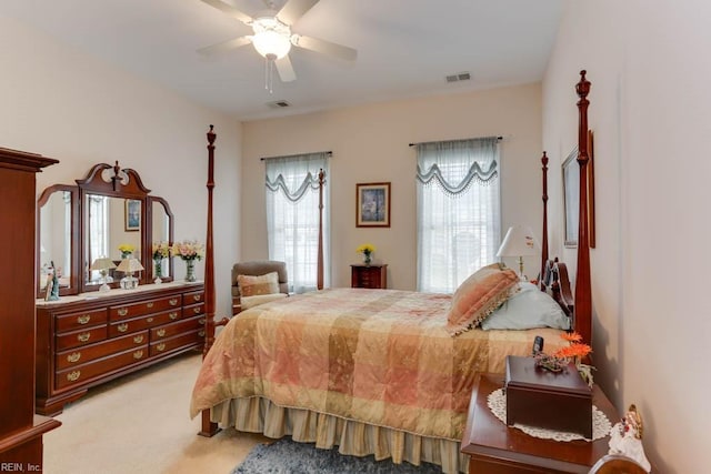 carpeted bedroom featuring ceiling fan, multiple windows, and visible vents