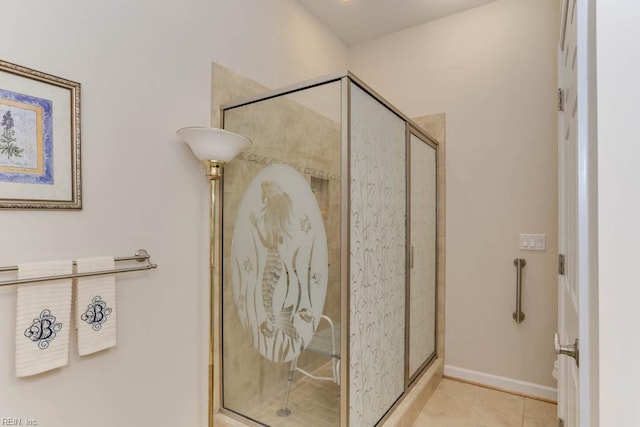 full bath with a stall shower, tile patterned flooring, and baseboards