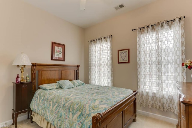 bedroom with baseboards, visible vents, ceiling fan, and light colored carpet