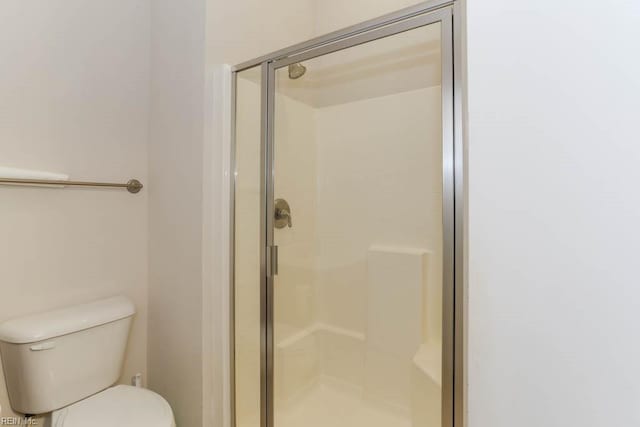 bathroom with a shower stall and toilet