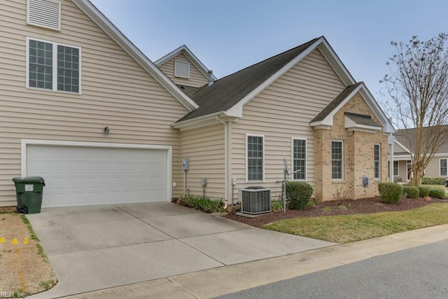 view of front of property with a garage, driveway, and cooling unit