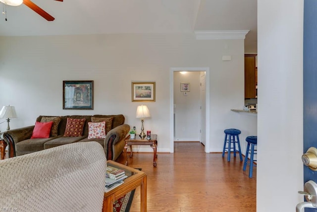 living room featuring ceiling fan, baseboards, and wood finished floors