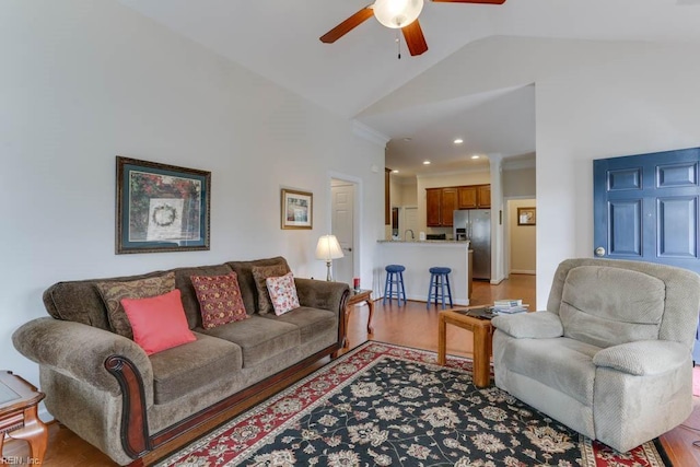 living area featuring lofted ceiling, light wood-style flooring, and ceiling fan