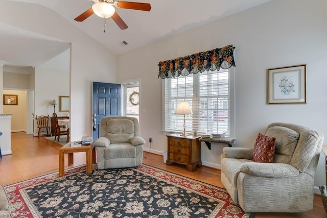 sitting room featuring baseboards, visible vents, ceiling fan, wood finished floors, and vaulted ceiling