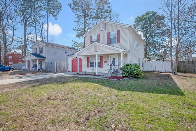 traditional home with a garage, fence, driveway, and a front lawn