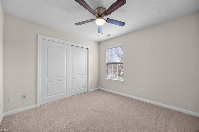 unfurnished bedroom featuring a closet, carpet, visible vents, and baseboards