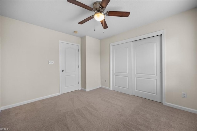 unfurnished bedroom with carpet floors, a closet, ceiling fan, and baseboards