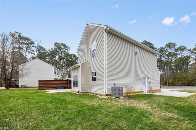 view of side of property with a yard, a patio area, cooling unit, and fence