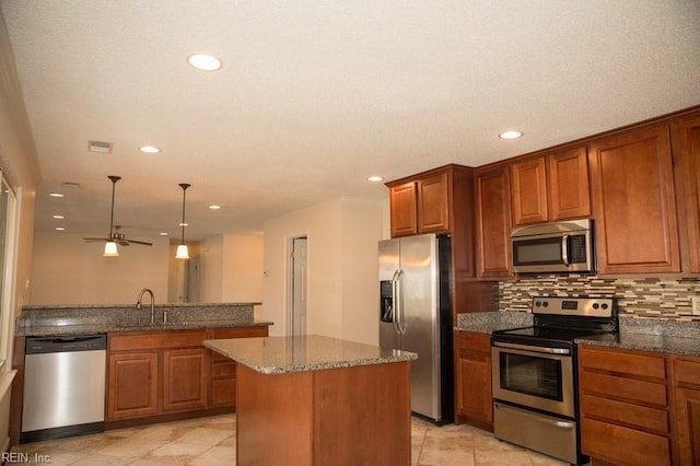 kitchen featuring decorative backsplash, appliances with stainless steel finishes, brown cabinets, and a sink