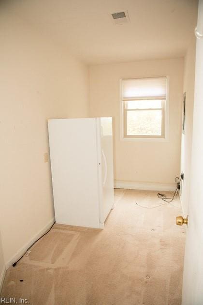 interior space featuring light carpet, visible vents, and baseboards