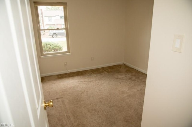 carpeted spare room featuring baseboards