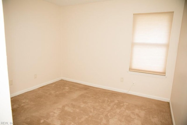 carpeted spare room featuring baseboards