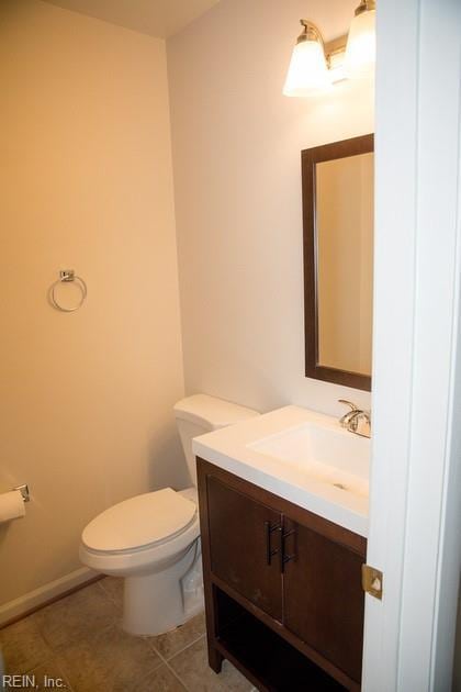 bathroom featuring toilet, vanity, baseboards, and tile patterned floors