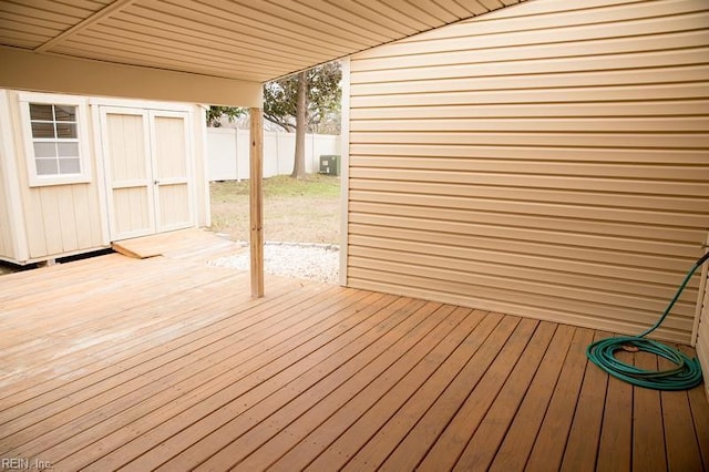 deck featuring fence, an outdoor structure, and a shed