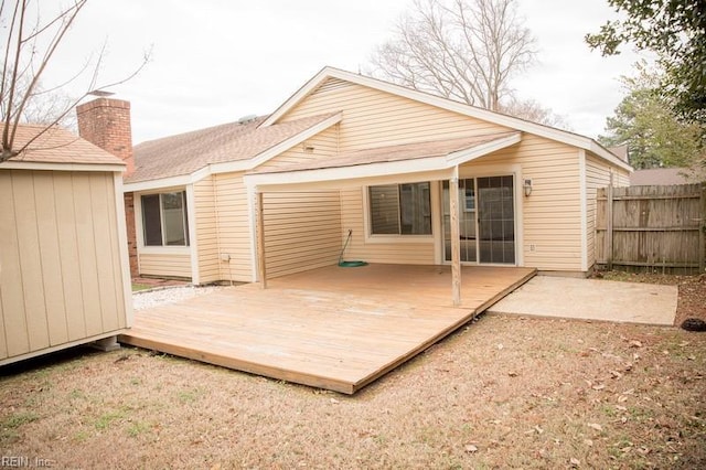 back of property with an outbuilding, fence, and a deck