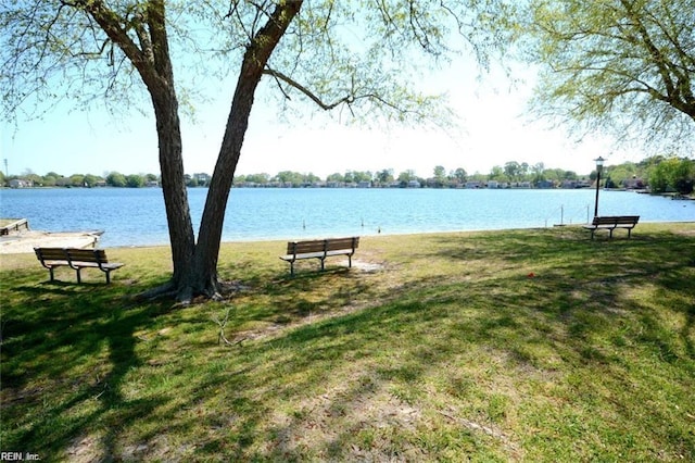 view of community with a lawn and a water view