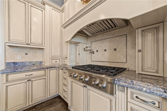 kitchen featuring decorative backsplash, stainless steel gas stovetop, cream cabinets, and dark wood-style floors