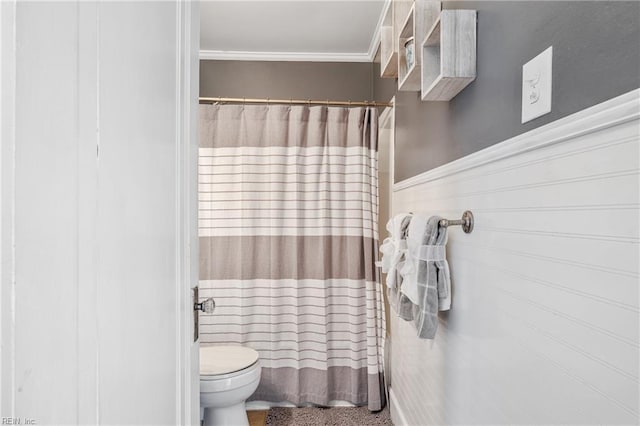 bathroom with a shower with shower curtain, wainscoting, and toilet