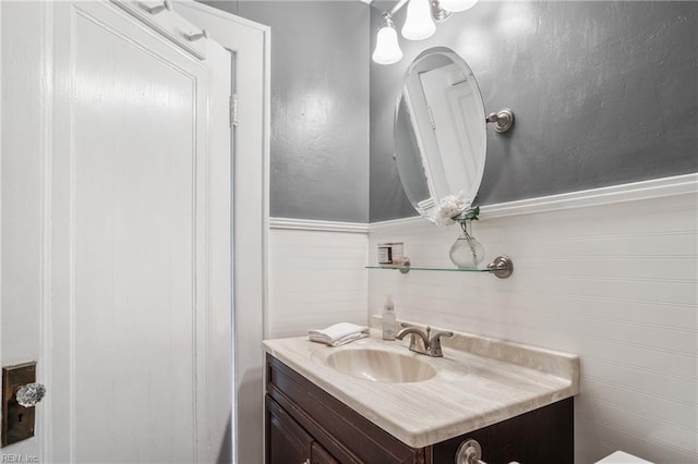 half bathroom with wainscoting and vanity