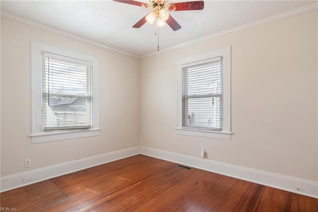 empty room featuring a ceiling fan, ornamental molding, hardwood / wood-style floors, and baseboards