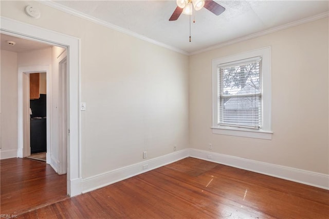 spare room featuring ornamental molding, ceiling fan, baseboards, and wood finished floors