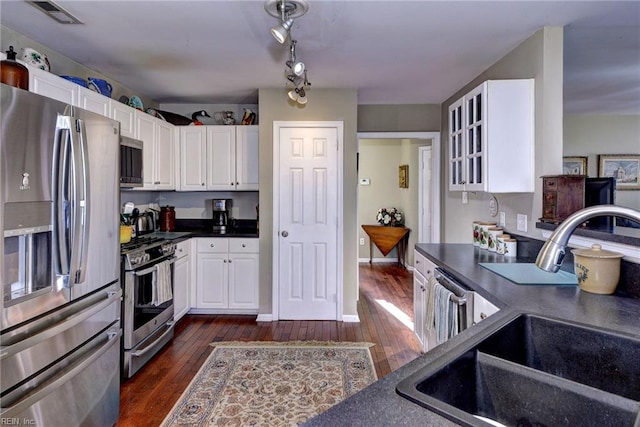 kitchen featuring a sink, visible vents, white cabinetry, appliances with stainless steel finishes, and dark countertops