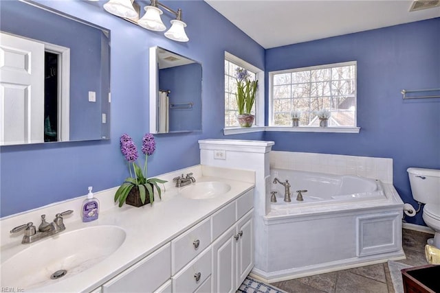 bathroom with visible vents, a sink, toilet, and a bath