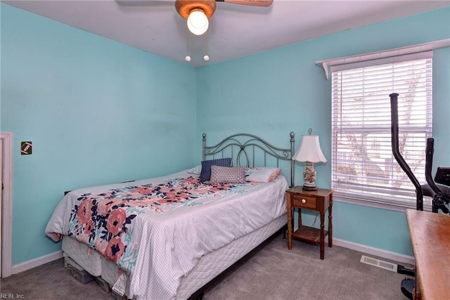 carpeted bedroom with visible vents, baseboards, and a ceiling fan