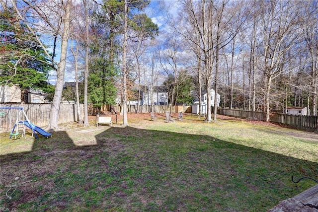 view of yard with a fenced backyard, a playground, an outdoor structure, and a storage unit