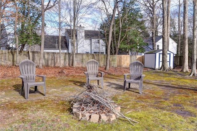 view of yard with a storage shed, fence, and an outbuilding