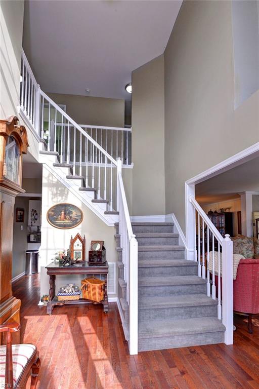 stairs featuring hardwood / wood-style floors and a high ceiling