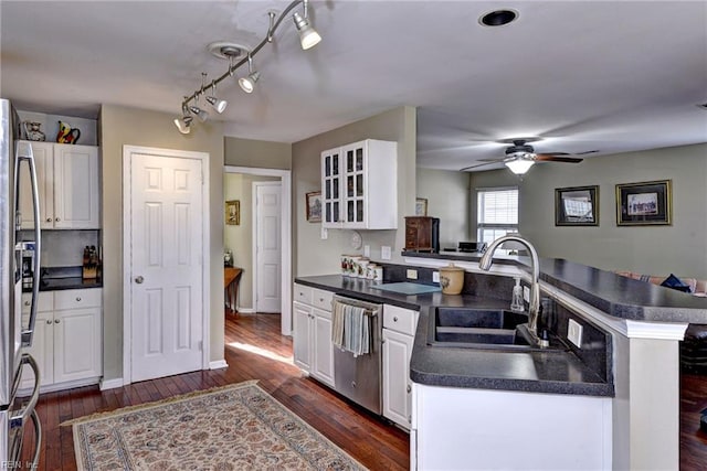 kitchen featuring dark countertops, white cabinetry, stainless steel appliances, and a sink