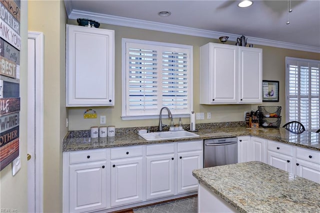 kitchen with a sink, stone counters, white cabinets, and crown molding