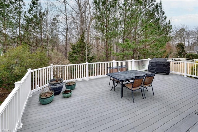 wooden terrace featuring outdoor dining area and grilling area