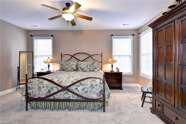 bedroom featuring a ceiling fan, visible vents, light carpet, and baseboards