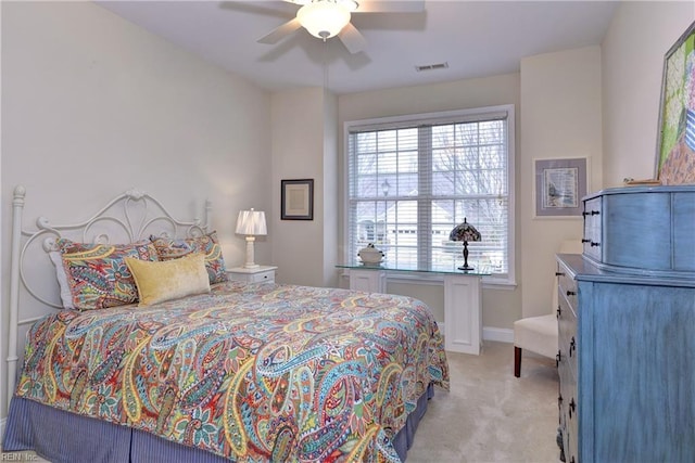 bedroom featuring baseboards, visible vents, ceiling fan, and light colored carpet