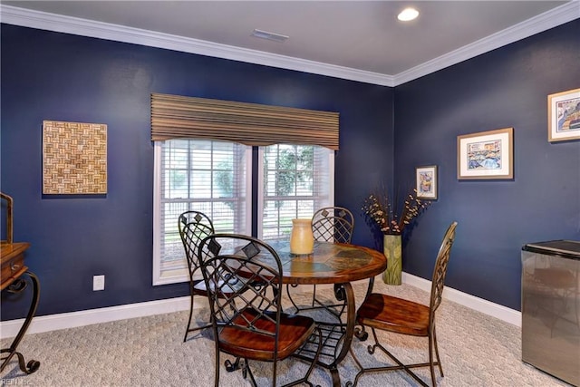 carpeted dining room featuring ornamental molding, visible vents, and baseboards