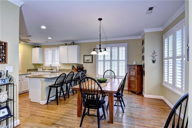 dining space with light wood-type flooring, baseboards, ornamental molding, and recessed lighting