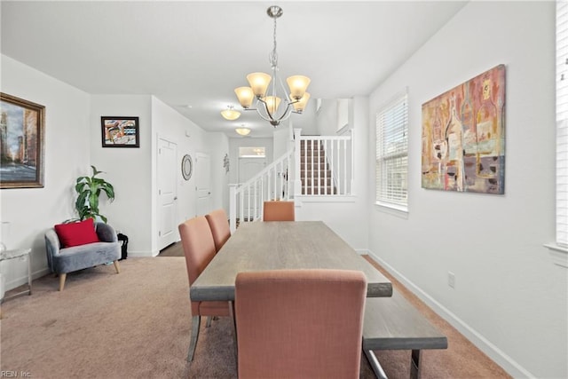 carpeted dining room with baseboards, stairway, and a notable chandelier