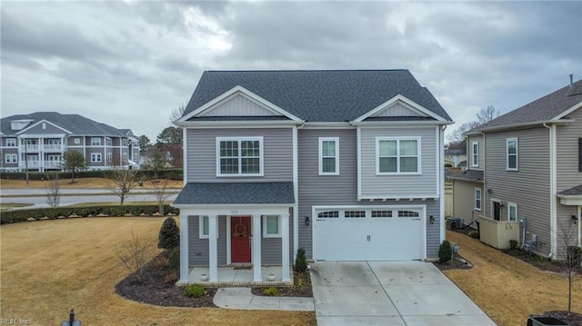 view of front of home featuring driveway, a garage, a front lawn, and roof with shingles