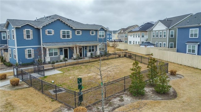 view of front of house with a residential view, a front lawn, and fence private yard