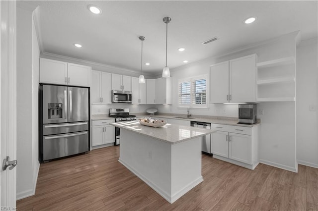 kitchen with visible vents, appliances with stainless steel finishes, ornamental molding, white cabinetry, and a sink