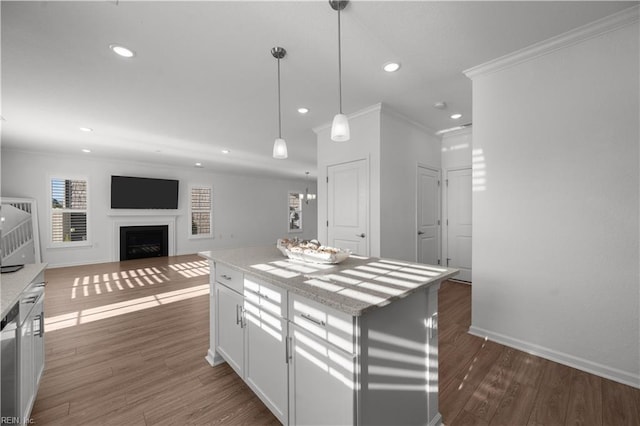 kitchen featuring a fireplace, wood finished floors, white cabinetry, and crown molding