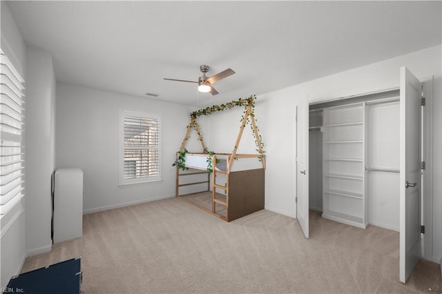 carpeted bedroom with baseboards, a closet, visible vents, and a ceiling fan