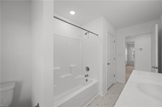 bathroom featuring vanity, shower / tub combination, toilet, and baseboards