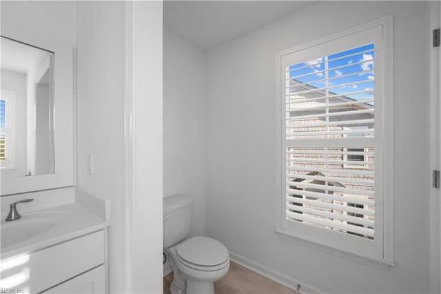 bathroom featuring baseboards, vanity, and toilet