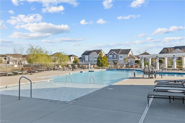 community pool with a patio area, fence, a residential view, and a pergola